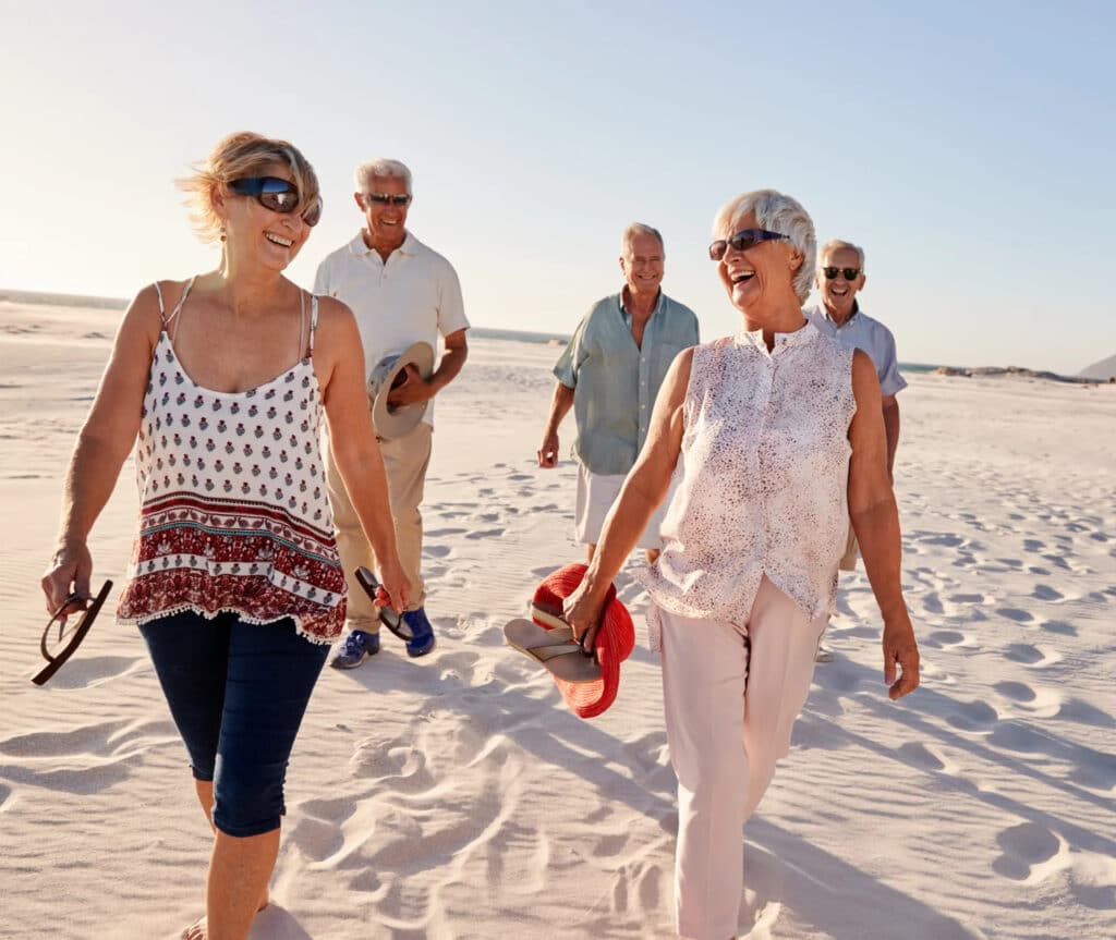 A group of old people walking on a beach