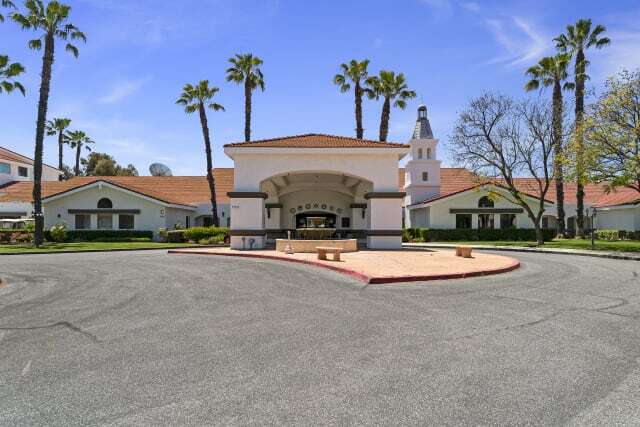 a building with a round driveway and palm trees