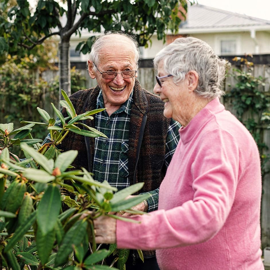 Senior's smiling while holding a plant