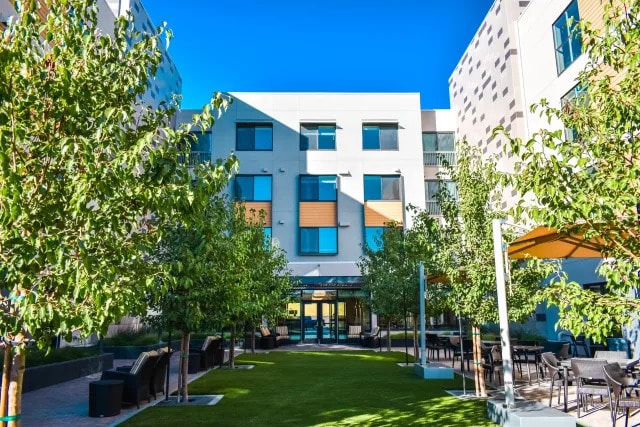 a building with trees and chairs