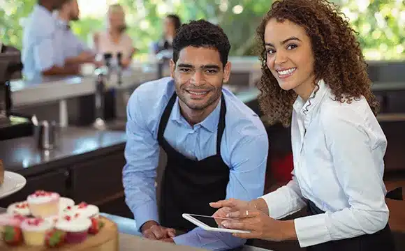 Two restaurant workers smiling at the camera