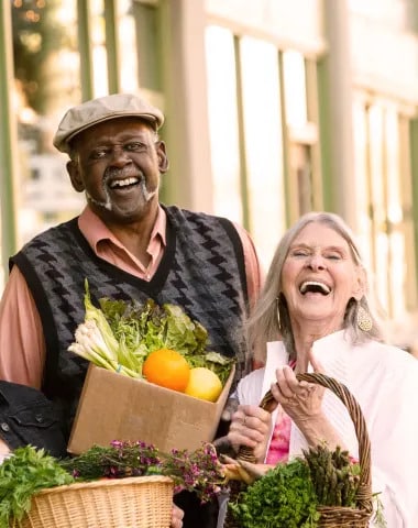 Senior's holding a basket of vegetables