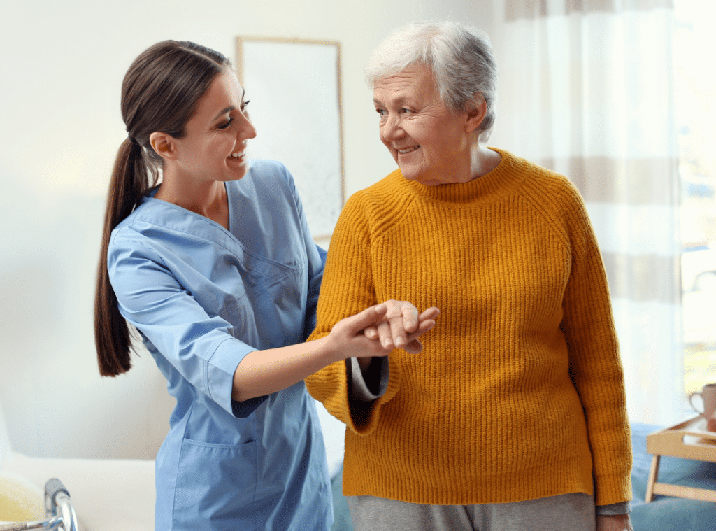 A woman assists an elderly woman by holding her hand, showcasing compassion and support in a caring interaction.